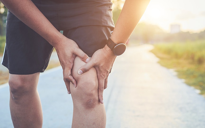 Osteoarthritis man clutching knee in pain